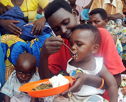 A mother feeding her kid during this yearu2019s Womenu2019s Day in Butamwa. The New Times / File.