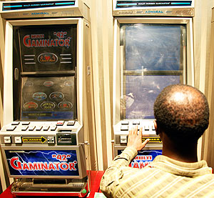 A gambler playing on  a slot machine.Gaming operators will be required to pay a tax rate of 13 per cent on all gaming activities.  The New Times / T.Kisambira.