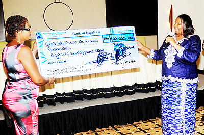 The Mayor of Nyarugenge District Solange Mukasonga (R) receives a cheque as contribution to Agaciro Fund by the district staff.  New Times / File