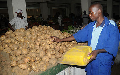 A man sells potatoes at the City market. Commodity prices have been on the increase in the past few months. The New Times / John Mbanda.