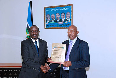 Rusenyanteko (R) receives an award from the EAC Secretary General Dr Richard Sezibera.