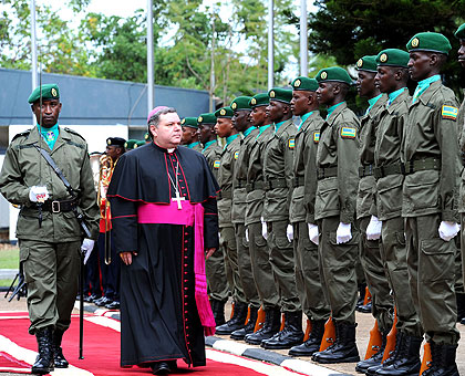 The new Papal Nuncio to Rwanda, Archbishop Luciano Russo, inspects a guard of honour at Village Urugwiro, yesterday. The New Times/ Village Urugwiro.