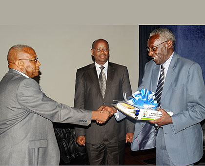 Senator Prof. Chrysologue Karangwa (R) hands over to his successor Kalisa Mbanda as the Minister of Local Government, James Musoni, looks on. The New Times / John Mbanda.