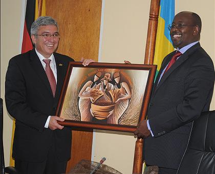 The head of the Rhineland-Palatinate delegation, Roger Lewentz (L), receives a gift from Local Government Minister James Musoni during their visit to MINALOC. The Sunday Times / John Mbanda.