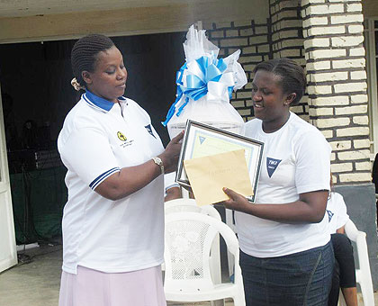 Mpinganzima (R) receives an award from the  Southern Province Executive Secreatary, Jeanne Izabiliza, during the ceremony. The New Times / JP Bucyensenge.