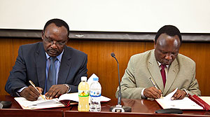 Minister Franu00e7ois Kanimba (L) signing  bilateral agreement with Gregory Teu, Tanzanian Deputy minister for Industry and Trade. The New Times / T.Kisambira.