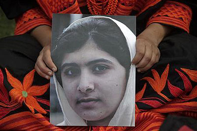 A student holds an image of Malala Yousufzai, who was shot on Tuesday by the Taliban, during a rally in Lahore October 14, 2012.  Net photo.