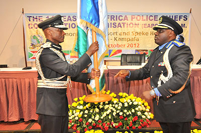 Lt Gen Kale Kayihura of Uganda, (L) receives a flag from Emmanuel Gasana to assume the rotational chairmanship of EAPCCO. Gasana later signed a pact with Ethiopia. The New Times / Courtsey.