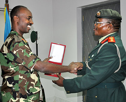 RDF Chief of Defence Staff Lt Gen Charles Kayonga (L) exchange  a gift from Col. Thomamo Makolo during the visit by the Botswana delegation to the RDF headquarters yesterday. The New Times / Courtesy.