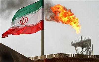 Gas flares from an oil production platform at the Soroush oil fields with an Iranian flag in the foreground in the Persian Gulf. Net photo.