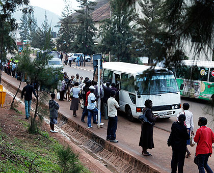 People wait for public transport at the bus stop near Kigali Central Prison. Drivers and car owners have said the new regulations are unfair. The New Times / File.