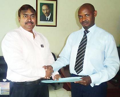 The New Media group Managing Editor, Satya Swaroop, exchanges files with Emmanuel Mugisha of the Media High Council after signing the capacity building pact. The Sunday Times / Courtesy.