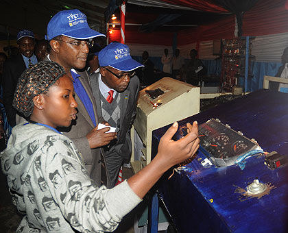 A female auto-mechanic student explains to Education Minister Vincent Biruta (2nd left) and State Minister Mathias Harebamungu how a petrol engine works, at the launch of the TVET Expo on Thursday.  The New Times / John Mbanda.