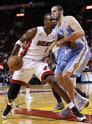 Miami Heat center Chris Bosh (left) drives up against Denver Nuggets center Kosta Koufos during the first half. Net photo.