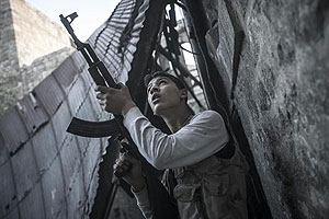 A rebel fighter watches windows in an overlooking building as he awaits for loyalists to President Bashar Assad to appear during heavy fighting in the Jedida district of Aleppo, Syria November 3. Net photo.