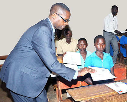 State Minister for Primary and Secondary Education Mathias Harebamungu distributes question papers at Munazi Primary School last year. The New Times, John Mbanda.