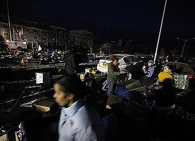 People look through piles of clothes at a sand -covered parking lot, unauthorised donation  centre in Rockaways. Net photo.