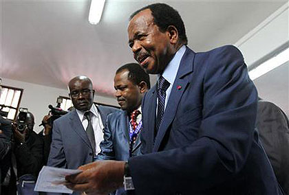 Cameroons President Paul Biya holds a ballot paper before casting his vote at a polling centre in the capital Yaounde October 9, 2011. Net photo.