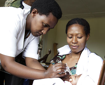 A medical officer administering an immunasation doze to an infant. Immunisation has been one of the areas where global fund has supported Rwanda. The New Times / File.