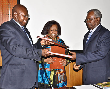 UN resident coordinator, Lamin Mamadou Manneh (L), exchanging documents with the Minister of Disaster Management and Refugee Affairs, Marcel Gatsinzi (R), and Neimah Warsame, UNHCR country representative. The New Times / T. Kisambira.