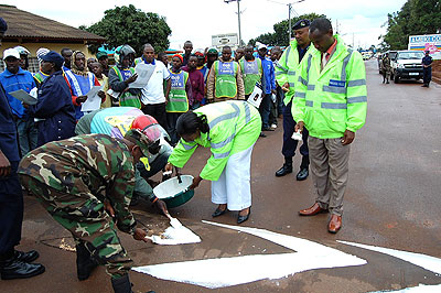 Governor Odette Uwamariya (C) joins police and drivers in drawing zebra crossings. The New Times / S. Rwembeho.