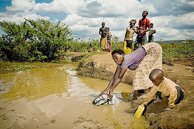 A woman and her child fetch water from a river in rural Rwanda; The country has taken key strides to increase access to water for all. Net photo