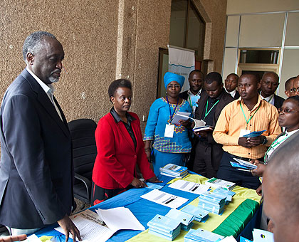 Senators Tito Rutaremara (L) and Marie Claire Mukasine explain to people who turned up for parliamentary Open Day yesterday. The New Times/Timothy Kisambira. 