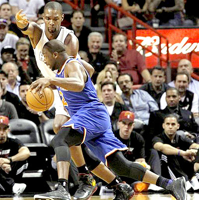 New York Knicks' Raymond Felton, foreground, drives around Miami Heat's Chris Bosh in the first half