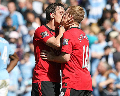 Gary Neville planted a kiss on Paul Scholes after he headed home late in the game at the Etihad. Net photo.