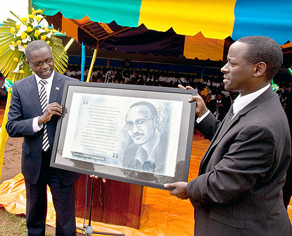 State Minister Dr Mathias Harebamungu (L), with Emmanuel Muvunyi, Deputy Director General, REB, display a painting of President Paul Kagame done by John Suuna a teacher at APRED Secondary School. The New / Timothy Kisambira.