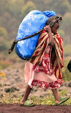 A child carrying a load way bigger than her age. The New Times / File.