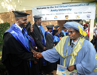 Coordinator of Tele-Education at KIE Irenee Ndayambaje (R) congratulates graduands of Distance Learning from Amity University. The New Times / John Mbanda.