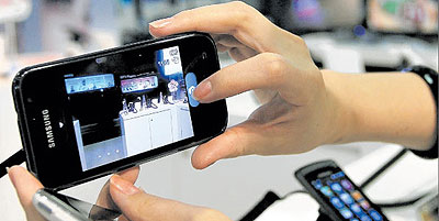 A consumer admiring a smartphone. Net photo.