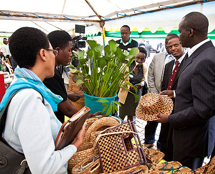 The Minister of Natural Resources, Stanislas Kamanzi, admires a hat made out of water hyacinth at the Public Accountability Day. The New Times/T. Kisambira.