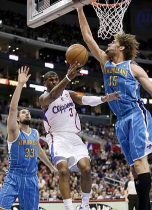 Clippers' Chris Paul shoots between New Orleans Hornets' Ryan Anderson, left, and Robin Lopez during the first half of an NBA basketball game. Net photo.