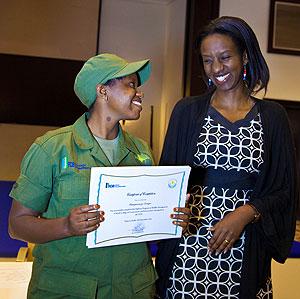 Rica Rwigamba(R), head of tourism and conservation at RDB shares a light moment with Denyse Umugwaneza after awarding her a certificate. The New Times/  T.Kisambira.