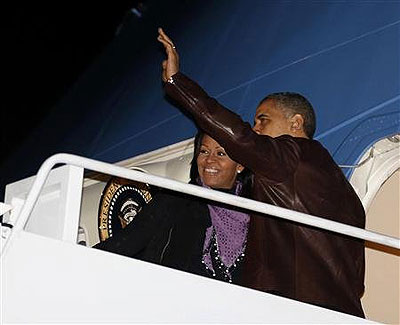 U.S. President Barack Obama waves next to first lady Michelle Obama as they prepare to depart Joint Base Andrews outside Washington, for their holiday trip to Hawaii. 