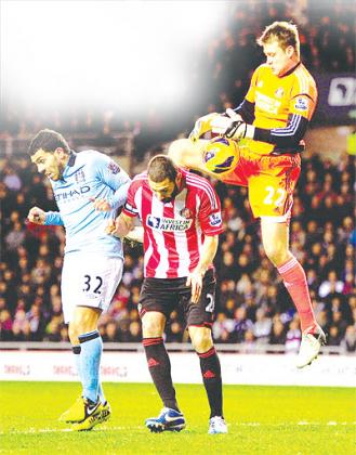 Sunderland keeper Simon Mignolet saves from Carlos Tevez and his own defender Carlos Cuellar at Stadium of Light on wedensday. Net photo.