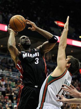 Miami Heat's Dwyane Wade (3) shoots the ball over Milwaukee Bucks' Beno Udrih during the first half. Net photo.