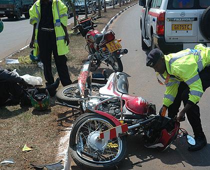 A traffic Officer lifts up a motor bike after it got involved in an accident. The Sunday Times / File.