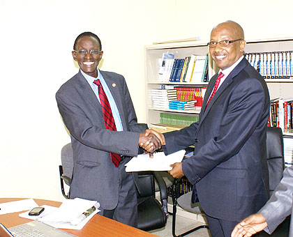 Prof. Rugege (L) hands over  instruments of office to Dr Mugisha at the NCHE offices recently. The New Times/ File