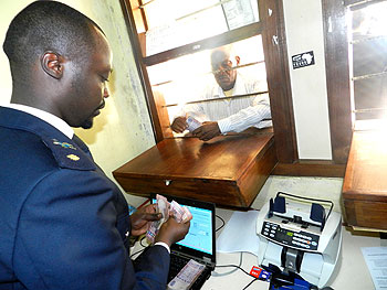 A customs official receives taxes from a businessman at Rusumo border. The New Times/  S. Rwembeho. 