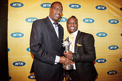 The Minister of Sports and Culture Protais Mitali (Left), poses for a photo with the winner of the 2011 Salax Awards, King James.  The New Times / File.