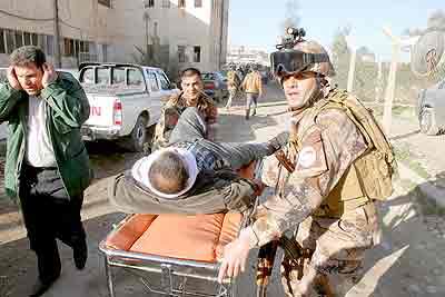 A wounded man is transported on a stretcher to receive treatment after a suicide bomb blast attack in Kirkuk. Net photo.