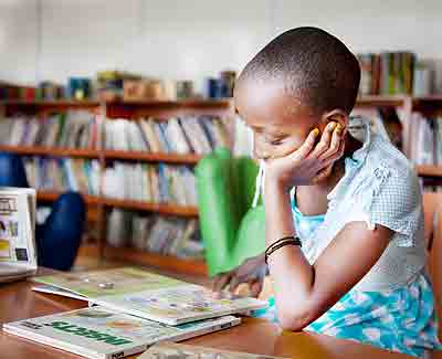 A pupil reads for pleasure in a school ttt       library. Such readings enhance academic excellence. The New Times/ Timothy Kisambira