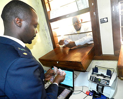 A customs official receives taxes from a businessman at Rusumo border. The New Times/ File. 