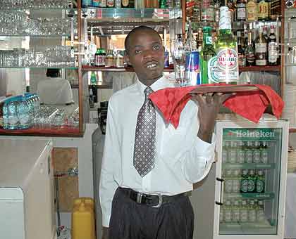 Waiters at work. Some students have taken up jobs in bars and restaurants in order to make ends meet. The New Times/ File.