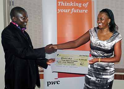 Mukeshimana (L) receives a dummy cheque from PwCu2019s Bernice Kimacia yesterday.  The New Times/John Mbanda.