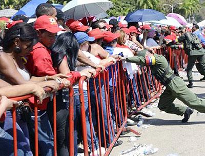 Venezuelan soldiers brace against protective fences as supporters wait in line to pay last respects to the late Venezuelan President Hugo Chavez outside the Military Academy in Caracas. Net photo