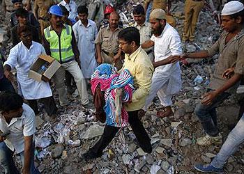 A rescue worker carries the body of a child who was recovered from the rubble. Net photo.